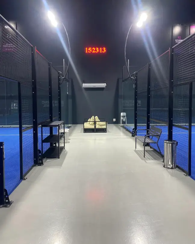 The aisle between both courts with AC units on the wall